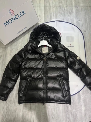 Moncler maya jacka - Hej! Jag säljer nu min svarta moncler maya. Den är i jättebra skick andvänt väldigt lite och sparsamt den har inga defekter eller liknande. Jackan har dun i sig så den är perfekt till den kalla hösten/vintern. Den är äkta och köpt på monclers hemsida inte så länge sedan. Jag säljer jackan pågrund av att jag inte har tid att andvända den då jag mest har jobbklädder på när jag jobbar. De ingår med dustbag, lapparna,. Hör av dig vid frågor och extra bilder!