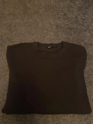 Grön långärmad tröja från Zara - En stilren grön långärmad tröja från Zara i storlek S. Tröjan har rund halsringning och är tillverkad i mjukt bomullsmaterial. Perfekt för dig som gillar enkla och klassiska plagg med en clean look. Hör av er vid frågor