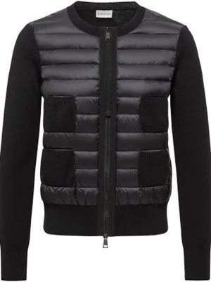 Svart pufferjacka från Moncler - Snygg svart pufferjacka från Moncler med quiltad front och stickade ärmar. Jackan har rund hals, två framfickor och dragkedja hela vägen. Perfekt för dig som vill ha en stilren och modern look med extra värme.