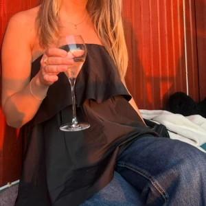 Svart volangtopp - Jättefin topp med volang som endast är använd en gång! Köpt på VeroModa. Materialet är ordentligt och ”prassligt”, med inte så att den låter massor när man rör på sig❣️