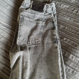 Grå Grunt jeans - Säljer ett par grå tvättade jeans som är lite baggy. Jeansen har en cool, lite stentvättad look och lös passform. Perfekta för dig som gillar en avslappnad stil med vintagekänsla. Använda ett par gånger, någon lite fläck och defekt kan man hitta vid en noggrann koll. Men inget som påverkar helhetsintrycket.