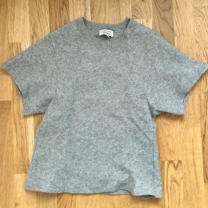 Grå ull-tshirt från & Other Stories - Säljer en grå t-shirt i mjuk ull från & Other Stories Stockholm Atelier.