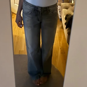 Grå wide jeans från Zara, stl 36 - Säljer ett par gråa jeans från Zara i storlek 36. Modellen är en bred, rak passform med normal midja och klassiska fem fickor. Jeansen är tillverkade i bomull och har en tvättad look.