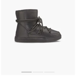 Svarta moon boots i skinn - Säljer ett par svarta inuikii boots med cool snörning runt hela skon. De är tillverkade i skinn och har en platt sula, perfekt för kalla dagar. Stilen är enkel men ändå trendig och passar dig som gillar streetwear. De är vattentäta och är i väldigt bra skick! Skriv för mer bilder💕