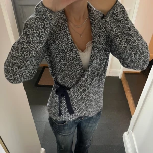 Blå stickad kofta  - Blå mönstrad kofta med snörning från Happy Holly i storlek 36/38. Fint skick. Använd gärna köp nu!