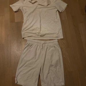 Vita frottéshorts med snörning - Säljer ett par vita shorts i mjuk frotté med elastisk midja och snörning. Shortsen har en avslappnad passform och sidofickor, perfekta för chill dagar eller sommarhäng. Enkel och clean look som är lätt att matcha med andra plagg.