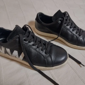 Wood Wood - klassiska svarta sneakers i skinn - Skitsnygga klassiska sneakers som är i skinn både invändigt och utvändigt. Mjuka och sköna. Färgen i loggan är lite "blekt". Fint använt skick. Storlek 40.