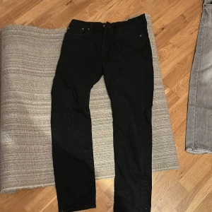 Svarta Levi's Premium jeans W32 L32 - Svarta Levi's Premium jeans i klassisk femficksmodell. Jeansen har rak passform och normal midja, tillverkade i ett mjukt och slitstarkt bomullstyg. Perfekta för dig som gillar stilrena och tidlösa svarta jeans.