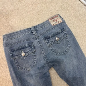True Religion ljusblå bootcut jeans - Säljer mina true religion jeans i modellen JOEY pga de inte kommer till användning. Storlek 27! Har använts 2 gånger. Köpta nypris 2999 från Johnells. Defekt: Har gjort ett extra hål vid midjan, det är ingenting som syns och kan skicka tydligare bilder privat 💗💗