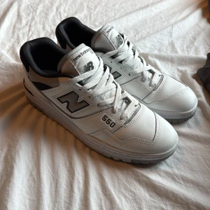 New Balance 550 vita sneakers - Säljer ett par New Balance 550 sneakers i vitt med svarta detaljer.  Väldigt bra skick och knappast använda.