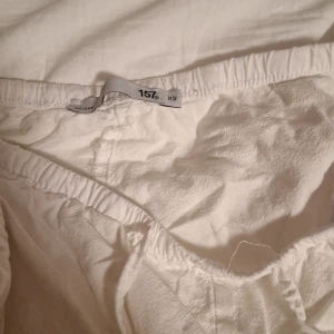 Vita linnebyxor med snörning XS - Säljer ett par vita linnebyxor i storlek XS. Byxorna har resår i midjan och snörning framtill för extra komfort. De är raka i modellen och har en avslappnad passform. Säljer pågrund av att de är lite korta i benen.