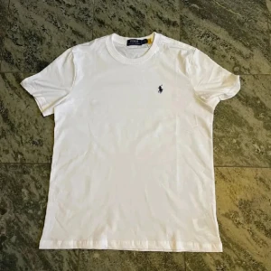 Vit t-shirt från Ralph Lauren - Säljer denna snygga Ralph Lauren T-shirten då den är för stor för mig. Passar er som har M eller är 177-187. Skriv till mig om ni har några funderingar. Pris går att diskuteras ‼️