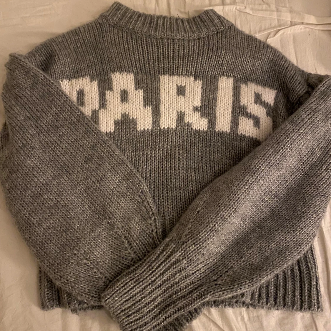 Grå stickad tröja med PARIS-tryck
