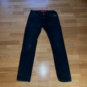 Mörkblå Replay jeans slim - Snygga mörkblå jeans från Replay. Klassisk femficksdesign slim fit och diskreta röda detaljer vid linningen. Jeansen är tillverkade i mjukt denimtyg som sitter skönt och passar perfekt till en avslappnad stil. W 31 L 34