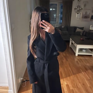 Lång kappa - Superfin lång kappa från H&M, perfekt till hösten och även vintern då den är lite tjockare. Den är i toppenskick. Som referens är jag på bilden ungefär 160