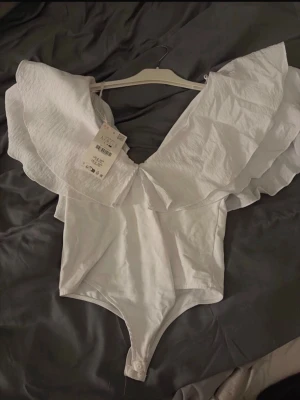 Vit omlott body med volang - Helt ny bara testad passar som m/s,jätte fin