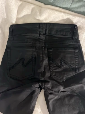Svarta bootcut byxor  - Snygga svarta byxor från Nelly med låg midja och bootcut passform. De är helt nya med prislappen kvar. Inte vanliga jeans utan mer åt det skinnliknande hållet🩷