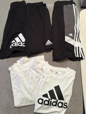 Ingen skor på bilden - Bilden visar inga skor utan endast shorts och t-shirts från Adidas och SOC. Kan inte ge någon skobeskrivning eller matchande taxonomier för skor. Ett sportpaket, men om du vill bara köpa en 49kr!