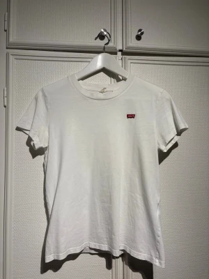 Vit t-shirt från Levi's - Säljer denna stilrena t-shirt från Levi's. T-shirten är gjord i mjuk bomull och har en normal passform. Säljer då den är för liten🌸