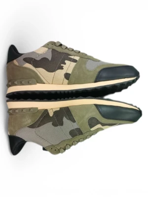 Valentino Rockrunner sneakers camo - Säljer ett par Valentino Rockrunner sneakers i camouflage. Skorna har en mix av mocka, mesh och skinn i gröna, beige och svarta toner. Klassisk snörning och coola nitar på hälen. Perfekta för dig som vill sticka ut med streetstyle-vibe.