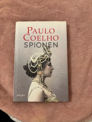 Spionen - En gripande berättelse om Mata Hari, en dansös och kurtsian som blev anklagad för spionage under första världskriget. Boken skildrar en modig kvinna som vågade gå sin egen väg och utmana samhällets normer. Perfekt för dig som gillar starka karaktärer och historiska öden.