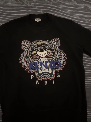 Kenzo tröja - Använd 1 gång så den är som ny, skick 9,5/10 absolut inga defekter alls inte ens minsta lilla tecken på användning. Skriv om ni vill köpa, jag fraktar och möts upp i Stockholm.