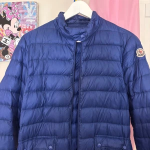 Blå dunjacka från Moncler - Snygg blå dunjacka från Moncler. Jackan har dragkedja framtill, fickor med lock och Moncler-logga på ärmen. Jackan är äkta men har inget kvitto då jag själv köpt den från sellpy (som endast får sälja äkta varor). Säljer för jag har för många jackor. Vid snabb affär, så kan pris diskuteras 💕