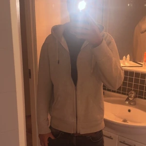 Grå hoodie från Polo Ralph Lauren - Säljer en grå zip hoodie från Polo Ralph Lauren med huva och 9/10 skick. Tröjan har två fickor och den klassiska Polo-loggan broderad på bröstet. Perfekt för chill dagar och enkel att matcha med jeans eller joggers. Fråga gärna och pris kan disskuteras:)) 