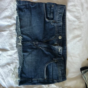 Mörkblå lågmidjade jeans kjol  - Från h&m, fint skick förutom att jag klippt kjolen själv så den blivit kortare! skriv för fler bilder. midjemått tvärs över ungefär 35 cm! 