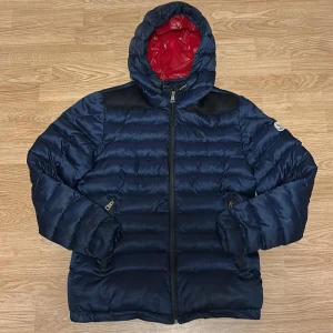 Mörkblå M pufferjacka - Säljer en mörkblå pufferjacka från M. Helt oanvänd och bra kvalité. Hör av er vid intresse!