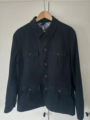 Dressmann overshirt herr L - Marinblå elegant superfin trendig overshirt/skjortjacka från dressmann i storlek L säljes. 4 bröstfickor och grym passform perfekt nu till våren. Sjukt fint skick och inga defekter alls!
