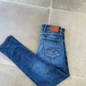 Replay anbass  - Ett par feta Replay Anbass jeans i Slim passform storlek 31/34. Väldigt bra skick förutom lappen där bak vars sömm har gått upp lite i hörnet men inget som syns när man har på sig dem. Kom gärna med frågor om du har några funderingar! Pris kan diskuteras.