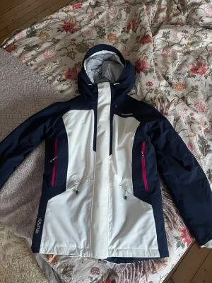 Skidjacka från peak performance  - Säljer min blå/ vita skidjacka mer rosa detaljer från peak performance då jag tyvärr har växt ur den. Det är i storlek S och i mycket fint sick. Finns fickor för luft på sidorna av jackan( se bild 3) Finns det frågor är det bara att höra av sig!🥰Går bra att buda!