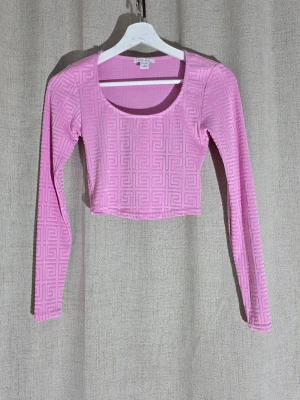 Rosa mönstrad tröja Amisu - En rosa långärmad tröia från Amisu i strl S. Tröian har ett mönster som är över hela tröjan. Den är i fint skick utan fläckar eller slitage. Katt finns i hemmet.