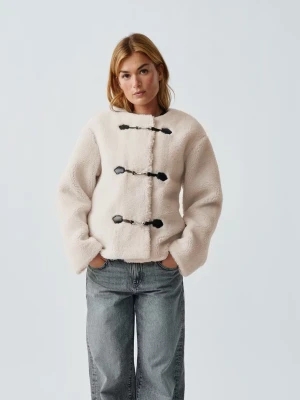 Beige teddyjacka med svarta detaljer - Supermjuk beige teddyjacka från Gina Tricot med raka ärmar och tre svarta spännen framtill. Jackan har en rund halsringning och är perfekt för att ge en mysig och trendig look. Materialet är fluffigt och ger en oversized känsla. Finns inte kvar att köpa från ginas hemsida längre💕