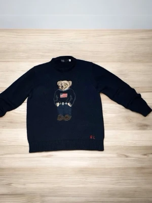 Ralph Lauren tröja  - HELT NY!! Säljer en klassisk mörkblå Polo Ralph Lauren nalle-tröja. Ikonisk design, fantastisk kvalitet och helt oanvänd. En tidlös favorit som passar till allt! Först till kvarn!! 