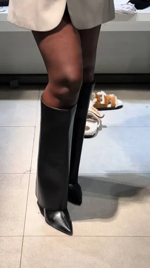 Svarta höga stövlar Zara - Säljer ett par svarta höga overfold stövlar ifrån Zara i skinn med spetsig tå och slät, elegant design. Stövlarna har en stilren look och passar perfekt till både kjol och klänning. De har en klassisk form och ger en riktigt trendig vibe. Klack cirka 6cm