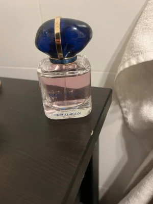 My Way parfym från Giorgio Armani - En elegant parfymflaska med ljusrosa doft från Giorgio Armani. Flaskan är genomskinlig med blå text och har ett lyxigt blått lock med gulddetalj. Perfekt för dig som gillar exklusiva och fräscha dofter.