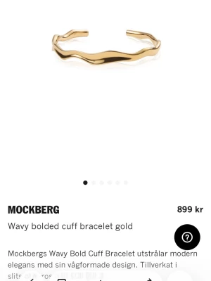 Guldfärgat vågigt armband Mockberg - Snyggt guldfärgat armband från Mockberg med vågformad, öppen design. Armbandet är tillverkat i metall och har en modern, stilren look som sticker ut. !Obs kartong medföljer ej!