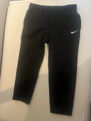 Svarta och grå mjukisbyxor från Nike 2 för 800 1 för 500 - Svarta mjukisbyxor från Nike med klassisk vit logga på ena benet. Byxorna har elastisk midja och är tillverkade i mjukt material som passar perfekt för chill eller träning. Enkel och stilren design som funkar till det mesta.