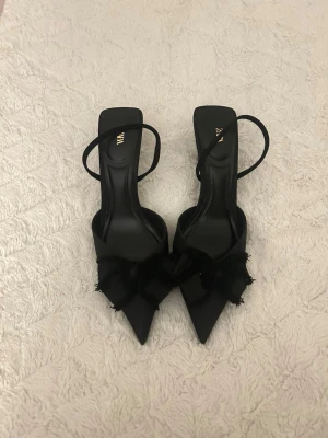 Svarta klackskor med rosett från Zara - Säljer dessa jättefina klackar från Zara har använt de ett fåtal gånger o super fina till en utekväll på sommaren🖤