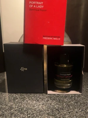 Portrait of a Lady parfym 100ml  - Frédéric Malle – Portrait of A Lady ?? En ljuvlig och ikonisk parfym med djup och elegans.  Doftnoter: • Topp: Svartvinbär, hallon • Hjärta: Turkisk ros, kryddnejlika • Bas: Patchouli, sandelträ, frankincense  Flaskan är 100 ml och endast öppnad för fotografering samt försiktigt testad med ett par spray. En sofistikerad doft med stark personlighet – den passade tyvärr inte min karaktär, men kommer garanterat att passa någon annan som uppskattar något unikt och elegant.