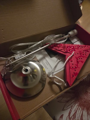 Röd julstjärna i metall från Markslöjd - Säljer en röd julstjärna i metall från Markslöjd med dekorativa utskärningar och blommönster. Stjärnan är avsedd att hängas i fönster och har tillhörande sladd, upphängning och lamphållare. Perfekt som juldekoration för att skapa mysig stämning.