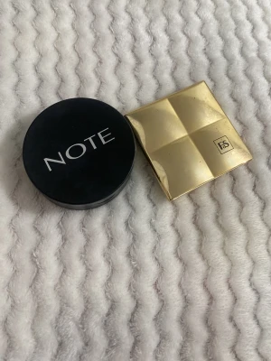 Highlighter från NOTE & FS - Två highlighters: en från NOTE i rund svart dosa med bronsig ton, och en från FdS i fyrkantig guldig dosa med marmorerad rosa och guldig nyans. Perfekta för att ge glow till ansiktet och framhäva kindbenen. Har inte använt dem helt nya