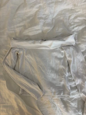 Vit långärmad topp från FB Sister - En enkel och stilren vit långärmad topp från FB Sister. Tillverkad i ett mjukt och tunt material som känns skönt mot huden. Perfekt att matcha med jeans eller kjol för en clean look. Klassisk rund halsringning och rak passform. Storlek L men passar som XS/S.