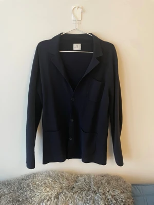 Mörkblå overshirt/blazer från John Henric - Stilren mörkblå overshirt från john henric i storlek M, väldigt bra skicka i princip inte använd, 80% bomull, funkar bra att över tshirt eller skjorta. Passformen är true to size