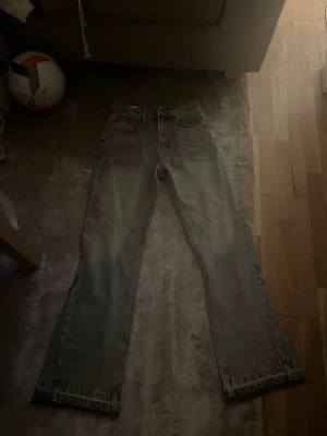 Grå raka jeans från Zara - Säljer ett par grå jeans från Zara med rak passform och klassisk femficksdesign. Jeansen har hög midja och är tillverkade i ett slitstarkt bomullsmaterial. Perfekta för en avslappnad och trendig look.