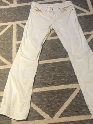 Vita jeans i size 14y - Snygga vita jeans med rak passform och klassisk femficksdesign. Jeansen är tillverkade i bomull och har en stilren look som passar perfekt till många olika outfits. Perfekta för dig som vill ha ett fräscht och stilrent plagg i garderoben.
