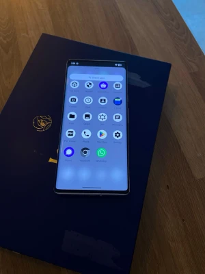 Google Pixel 6a Pro vit 128GB inga skador - Säljer en Google Pixel 6 Pro i vit färg med 128GB lagring. Telefonen har en stor, böjd OLED-skärm och en unik svart kamerarem på baksidan. Snygg och modern design med glasbaksida och metallram. Perfekt för dig som vill ha en snabb Android-telefon med grym kamera.