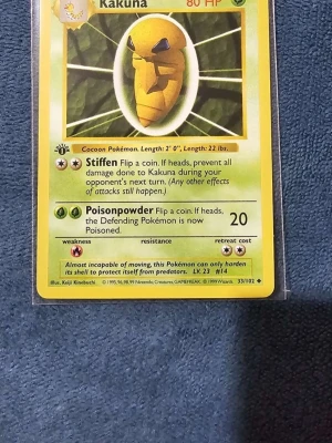 Kakuna #33 1st Edition  - Klassiskt Kakuna-kort från Pokémon Base Set, nummer 33/102. Kortet har en gul och grön design med illustration av Kakuna och detaljer om dess attacker och egenskaper. Perfekt för samlare eller Pokémonfans som vill utöka sin kortsamling.
